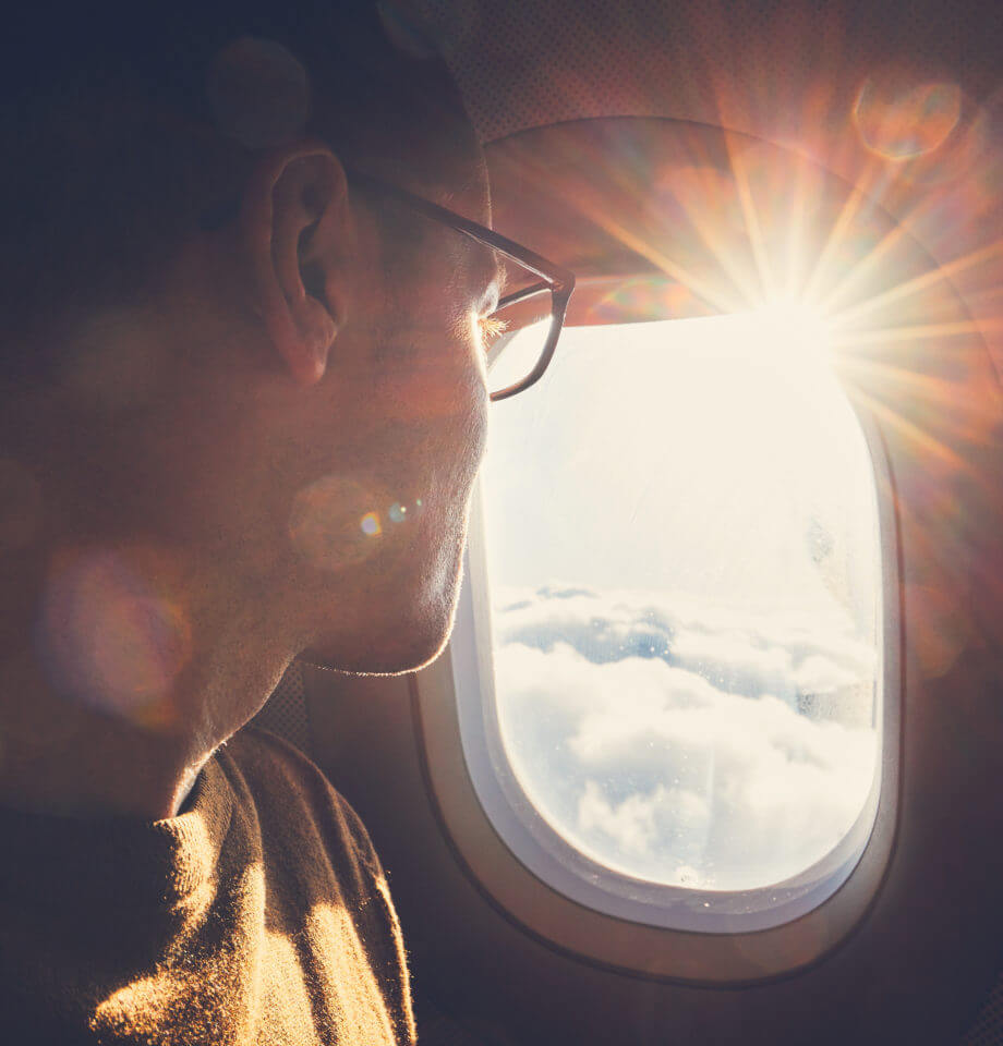 Person looking at clouds out of plane window